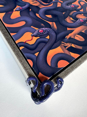 Detail of Framed painting with sculptural serpentine corners. The painting on red ochre of a female medusa figure enshrouded with purple snakes with their red tongues out.