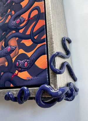 Corner detail of Framed painting with sculptural serpentine corners. The painting on red ochre of a female medusa figure enshrouded with purple snakes with their red tongues out.